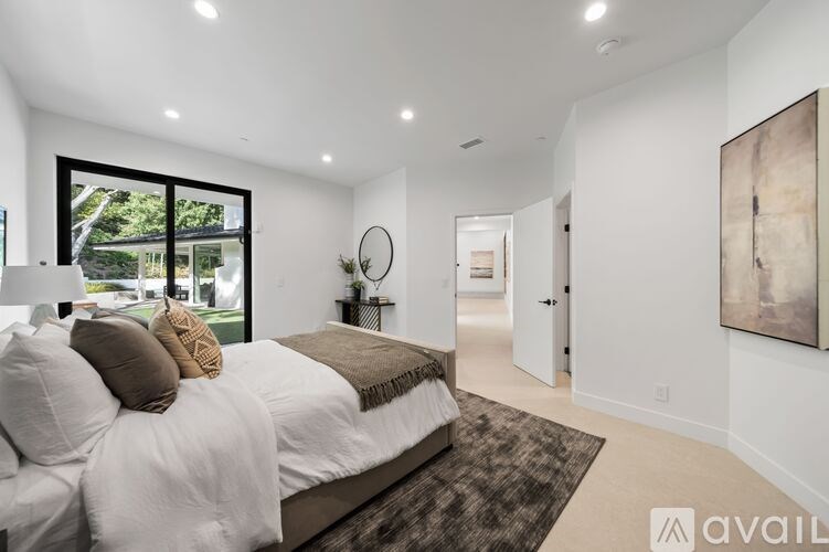 A bedroom with a large bed and a painting on the wall.