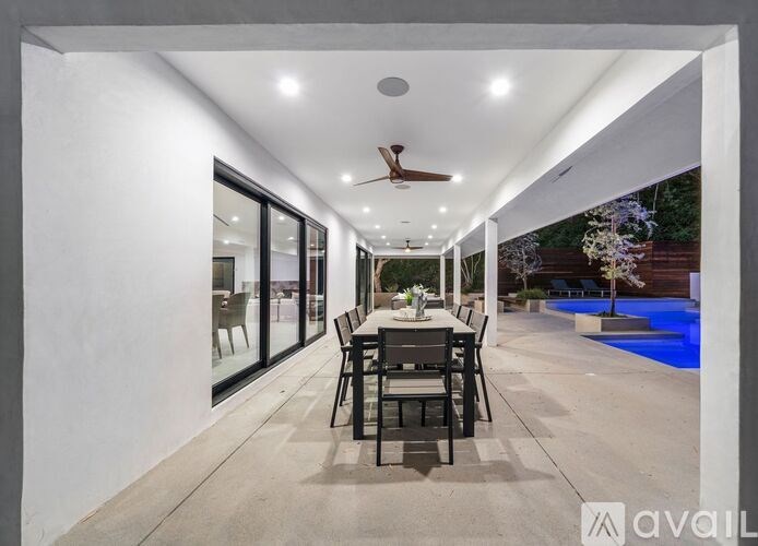 A modern dining area with a pool in the backyard.