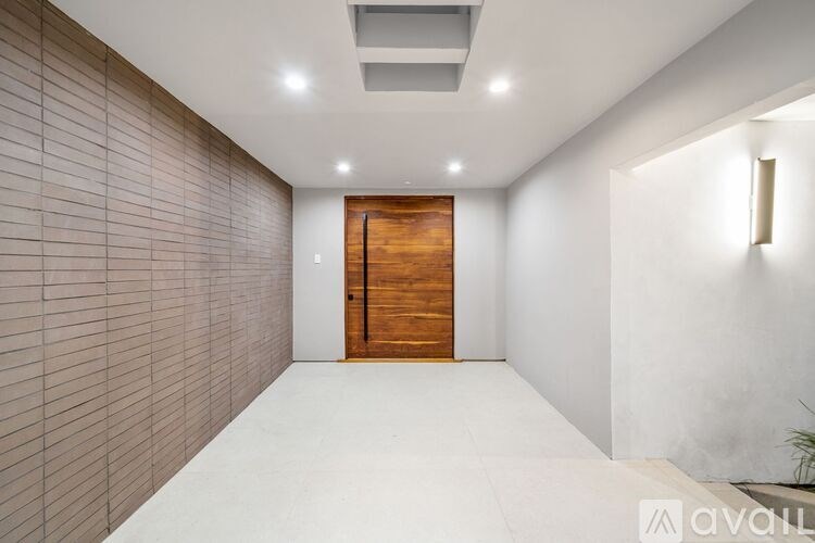 A hallway with a wooden door and tiled walls.