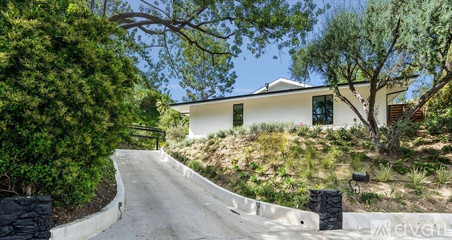 A white house with a green tree in front of it.