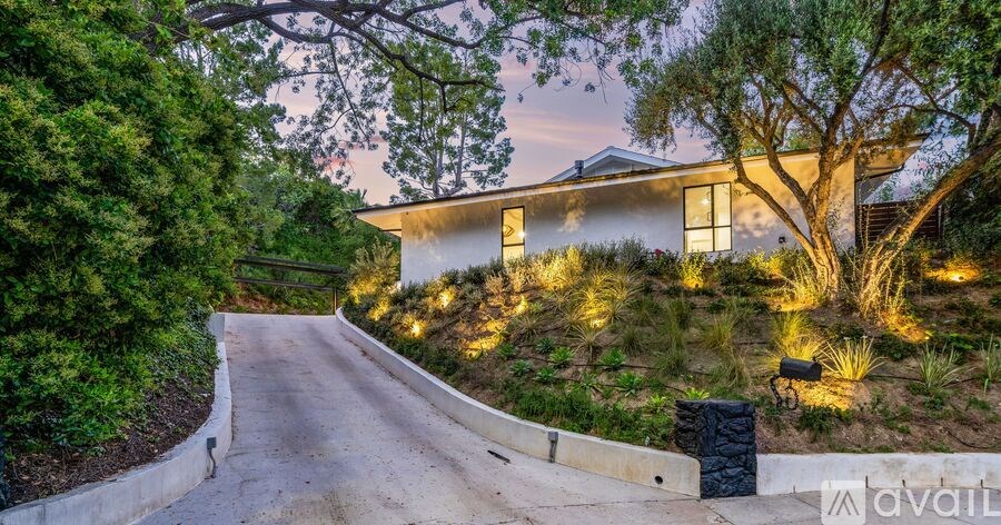 A house is lit up at night with lights on the front yard.