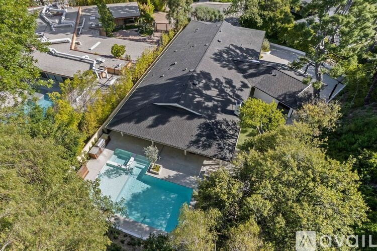 A house with a pool surrounded by trees.