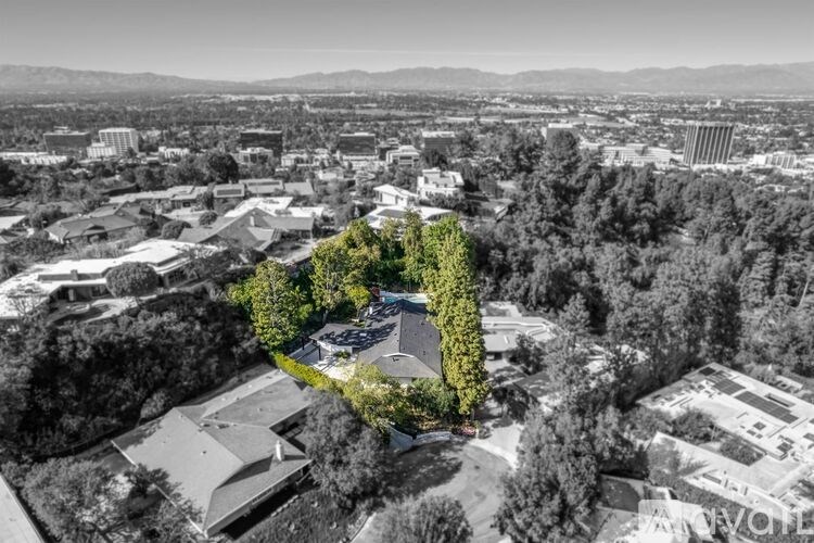 A black and white aerial view of a building surrounded by trees.
