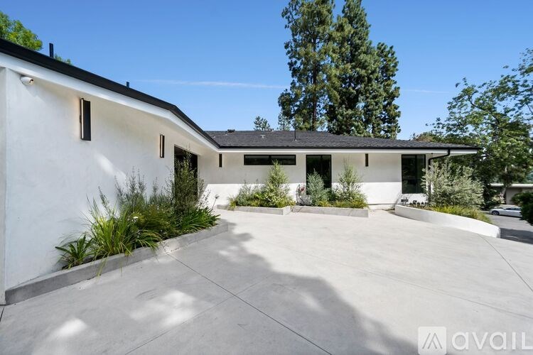 A modern house with a white exterior and a black roof.