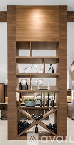 A wooden shelf with bottles and glasses on it.