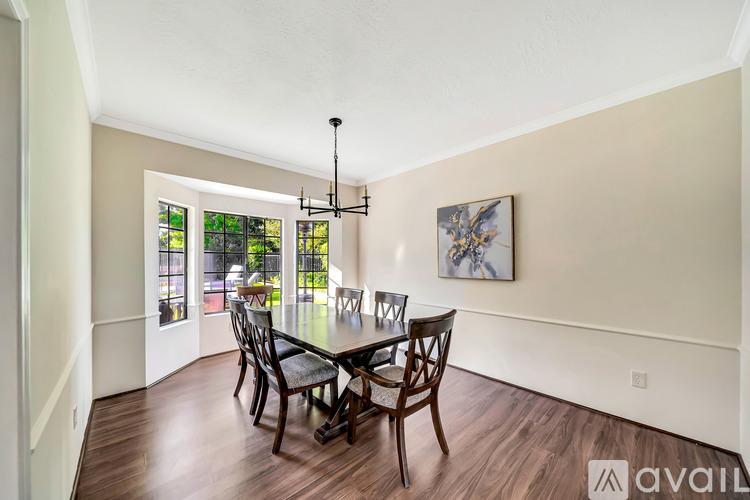 A dining room with a wooden table and chairs.