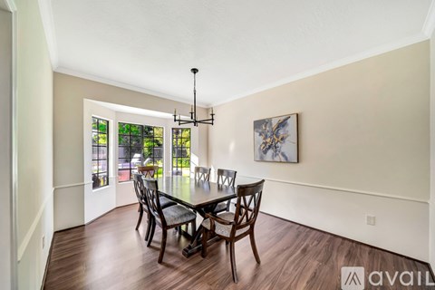 A dining room with a wooden table and chairs.