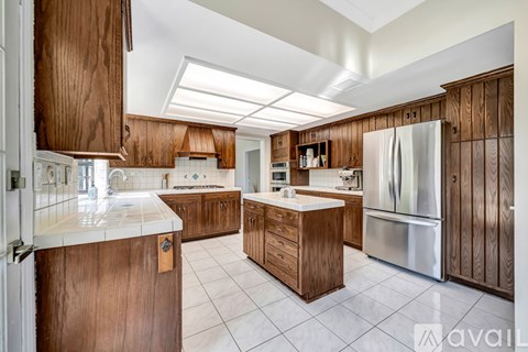 A kitchen with wooden cabinets and a white refrigerator.