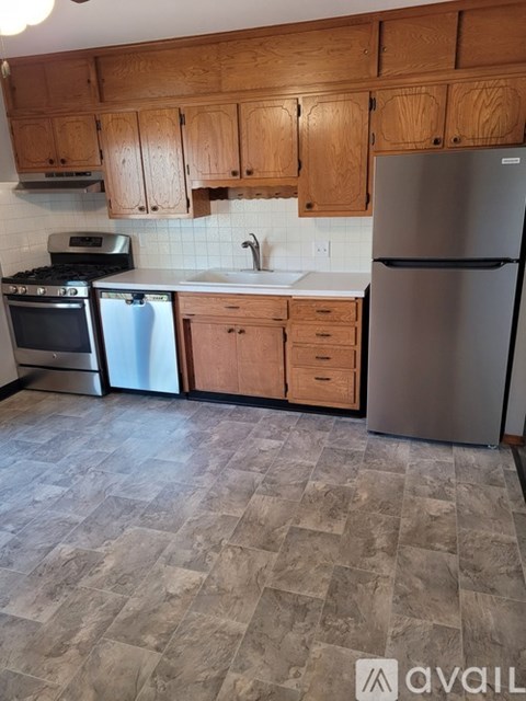 A kitchen with wooden cabinets and a tiled backsplash.