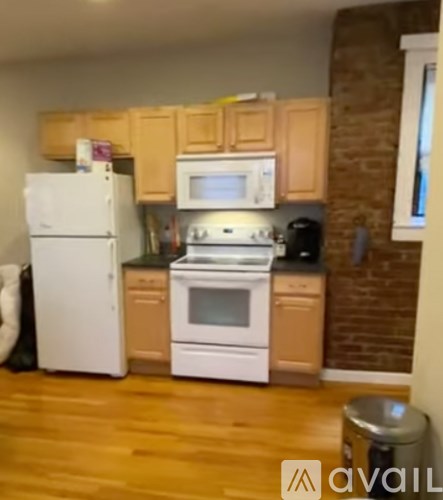 A kitchen with wooden cabinets and white appliances.