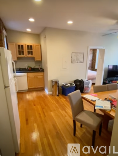 A kitchen with a refrigerator, table and chairs.