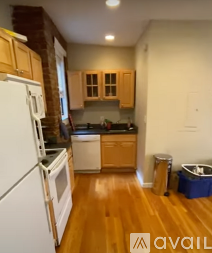 A kitchen with wooden floors and white appliances.
