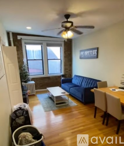 A living room with a blue couch and a ceiling fan.