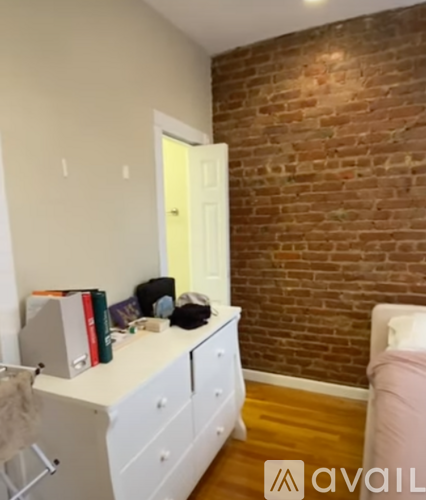 A room with a white desk and a brick wall.