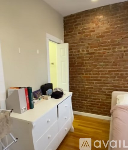 A room with a white desk and a brick wall.