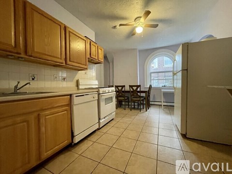 A kitchen with wooden cabinets and white appliances.
