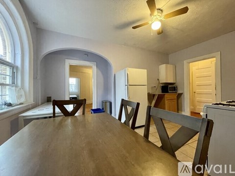 A dining room with a wooden table and chairs.