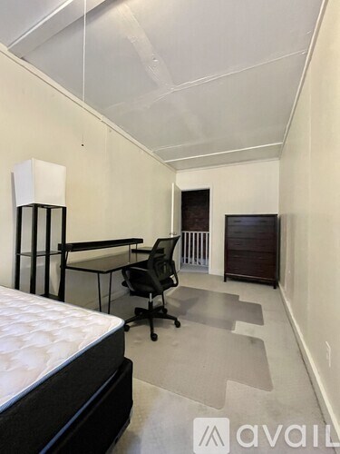 A bedroom with a bed, desk, and chair.