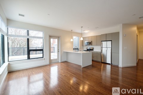 A spacious kitchen with white cabinets and a wooden floor.