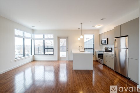 A spacious kitchen with stainless steel appliances and wooden floors.