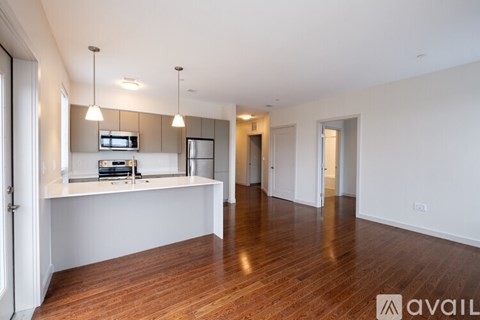 A spacious room with wooden floors and a white countertop with a microwave and oven.