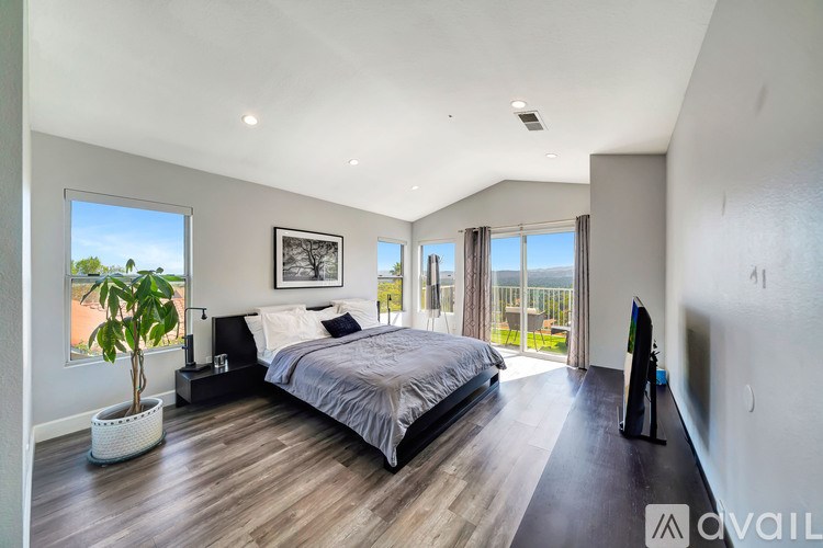 A bedroom with a large bed and a flat screen TV.