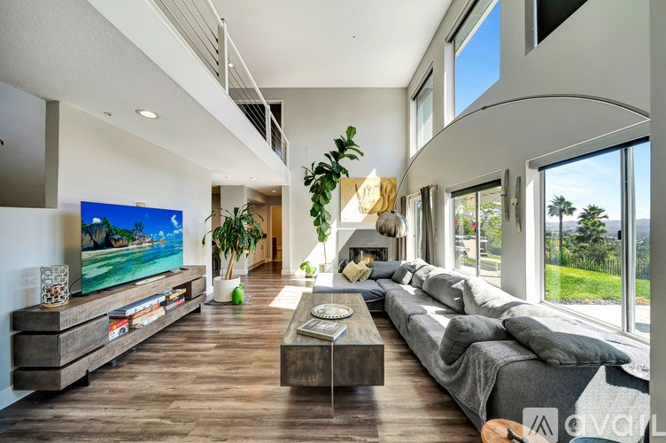 A modern living room with a large grey sofa and a wooden coffee table.
