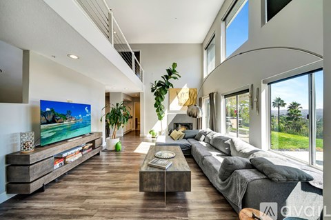 A modern living room with a large grey sofa and a wooden coffee table.
