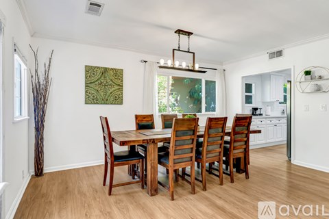 A dining room with a wooden table and chairs.