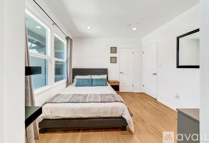 A bedroom with a bed, a mirror, and a window.