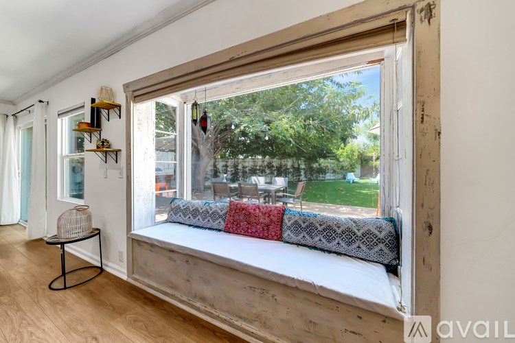 A room with a window seat and a table.