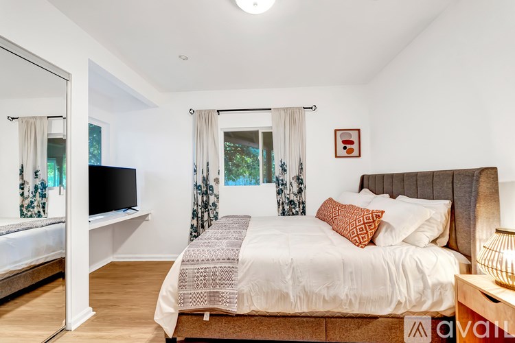 A bedroom with a large bed and a flat screen TV.