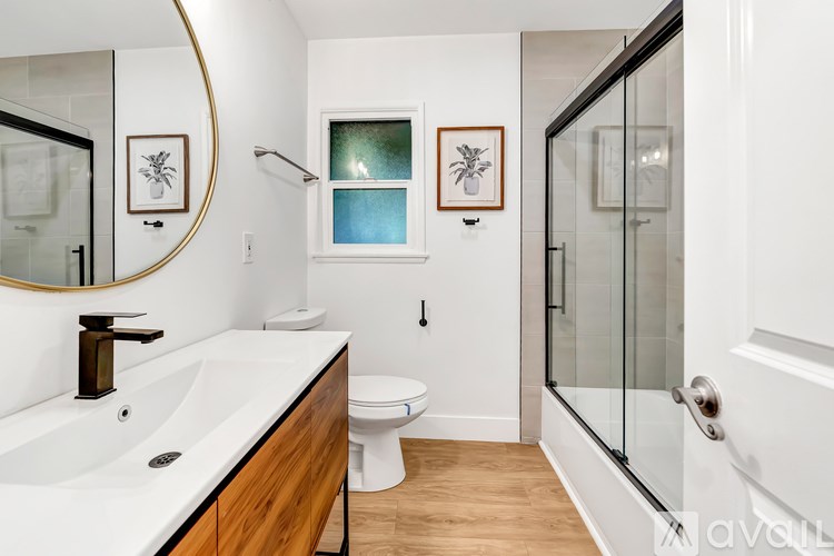 A bathroom with a white sink and a round mirror.
