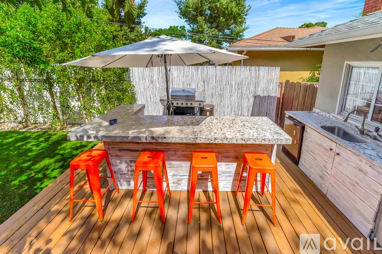 A patio with a table, chairs and an umbrella.