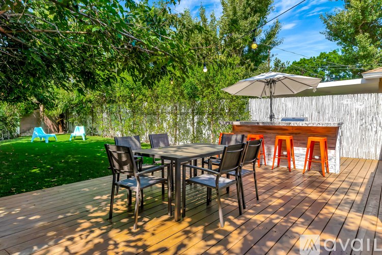 A wooden deck with a table and chairs and an umbrella.