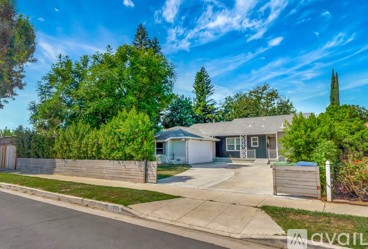 A house with a driveway and a fence in front of it.