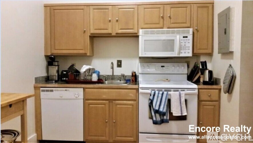 A kitchen with wooden cabinets and a white dishwasher.
