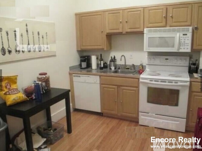 A kitchen with wooden cabinets and white appliances.