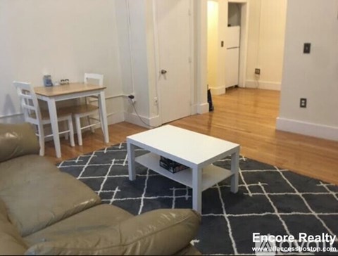 A living room with a white couch and a coffee table.