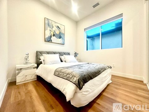 A bedroom with a large bed and a painting on the wall.