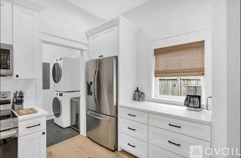 A kitchen with white cabinets and stainless steel appliances.