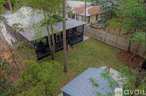 A backyard with a deck and a hot tub.