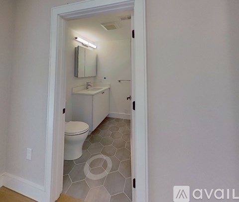 A bathroom with a toilet, sink, and mirror.
