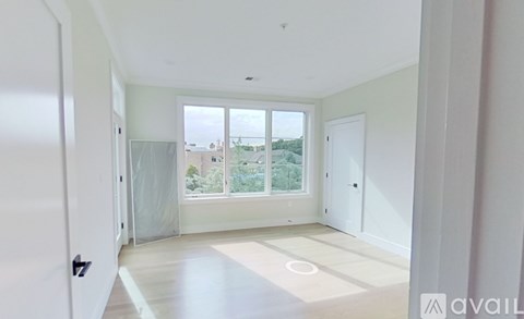 A spacious room with a view of the outdoors through the windows.