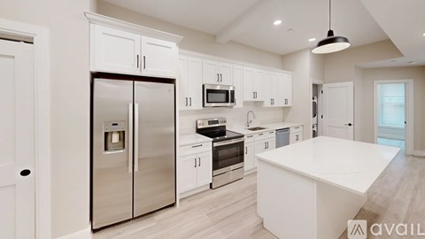 A kitchen with white cabinets and a stainless steel refrigerator.