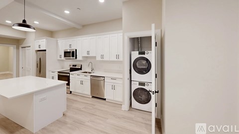 A modern kitchen with white cabinets and a white island.