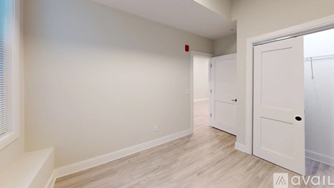A room with a white door and a window with blinds.