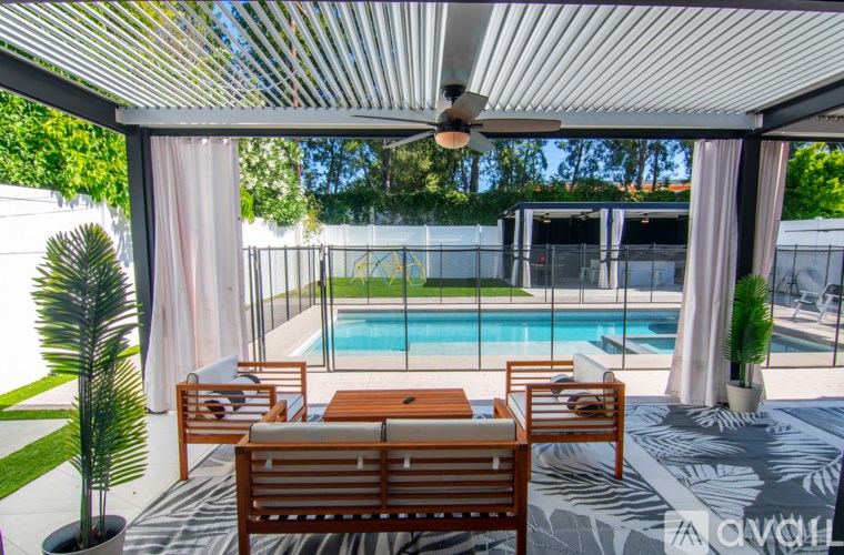 A patio with a pool and a table with chairs.