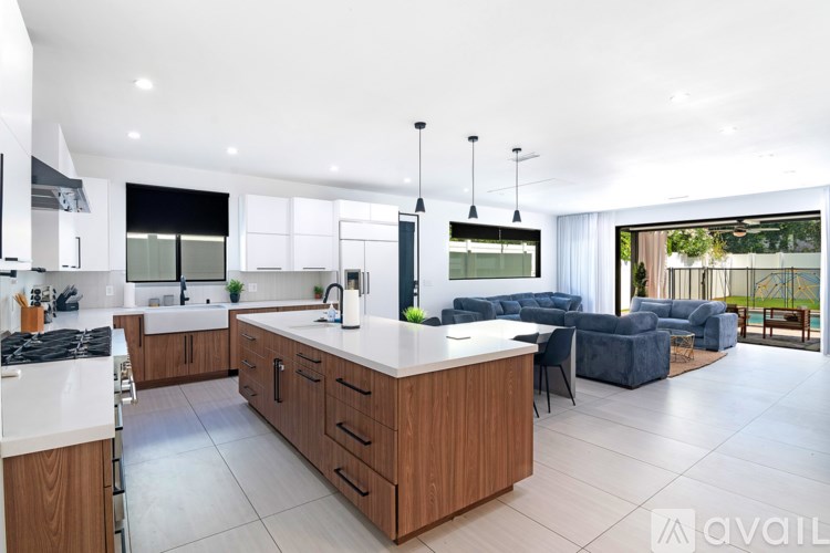 A modern kitchen with a large island and a view of the backyard.