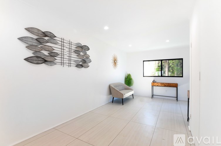 A modern living room with a large sculpture on the wall and a couch.